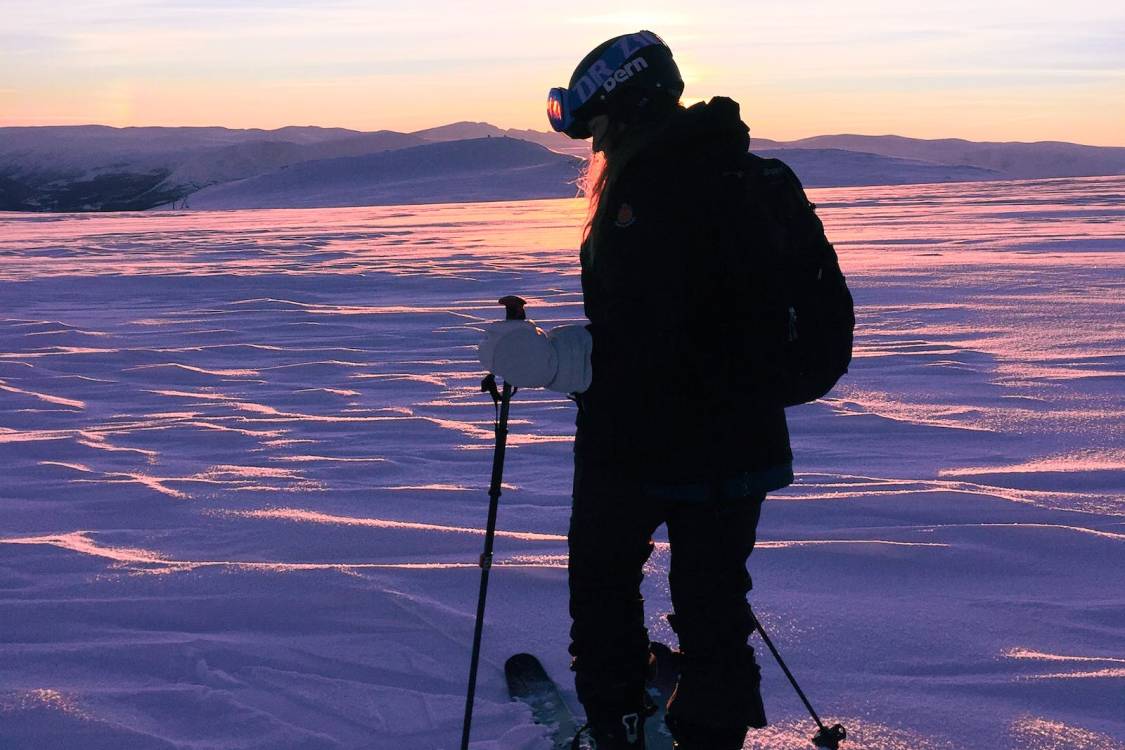 Skier in blue gear mid-air at Mt Buller with Mt Buller Snow Tours – Thrilling ski adventure